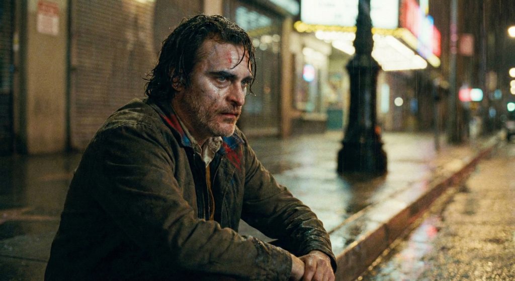 Joaquin Phoenix looking exhausted, regretful, and physically drained out of his Joker makeup.