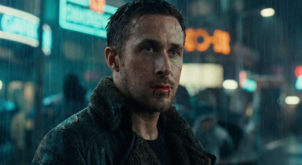 Ryan Gosling as Officer K in Blade Runner 2049 looking bloody and exhausted in the rain.