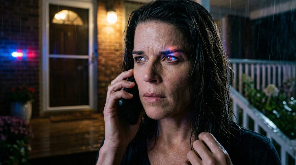 Close up of Neve Campbell as Sidney Prescott in Scream 7 looking intense on a rainy night.